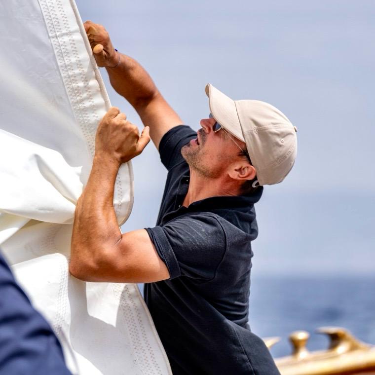 Hadrien Berghmans handling sail on deck aboard a classic yacht